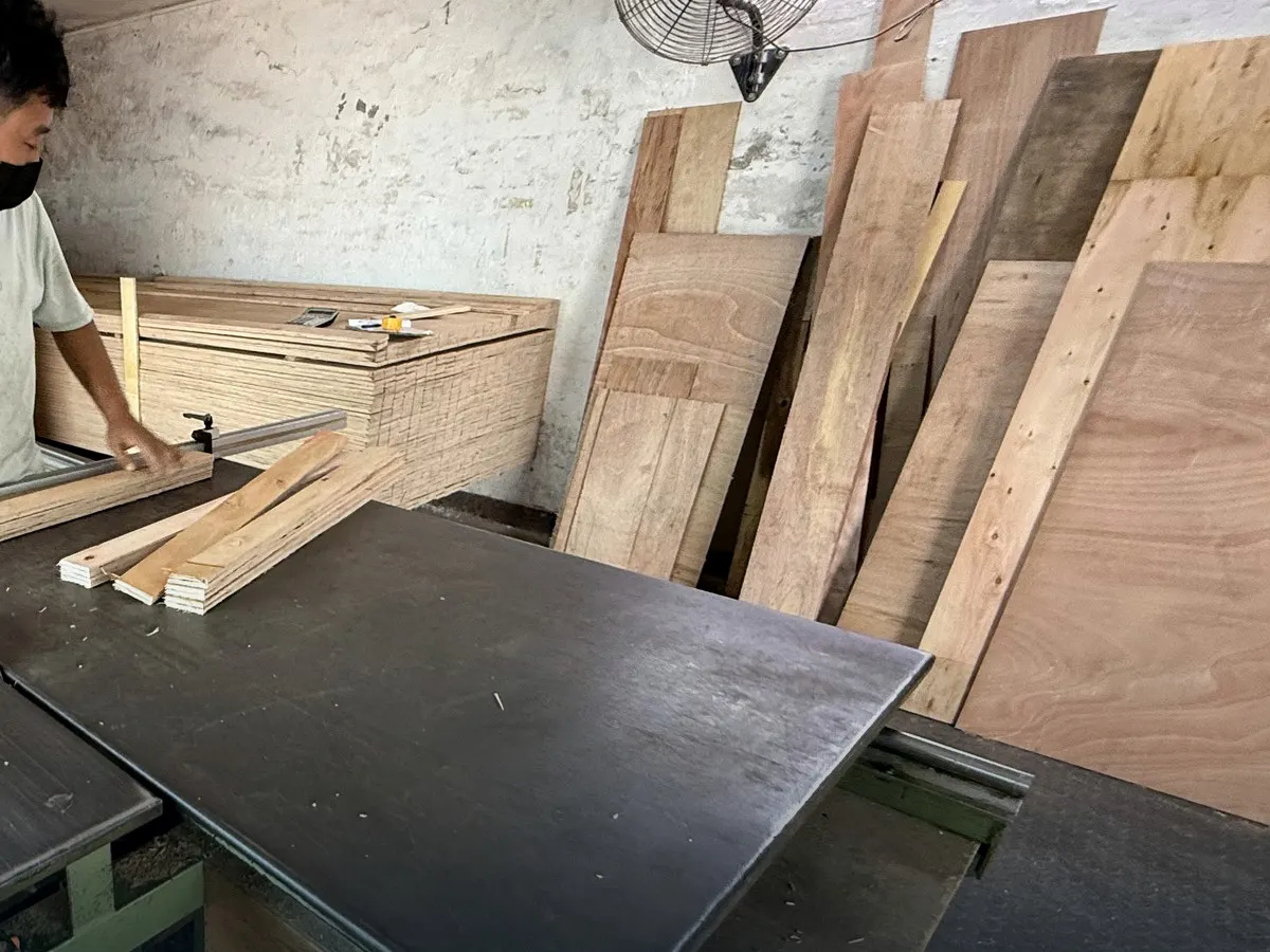 Worker measuring wood panels for a custom bulky-cargo crate