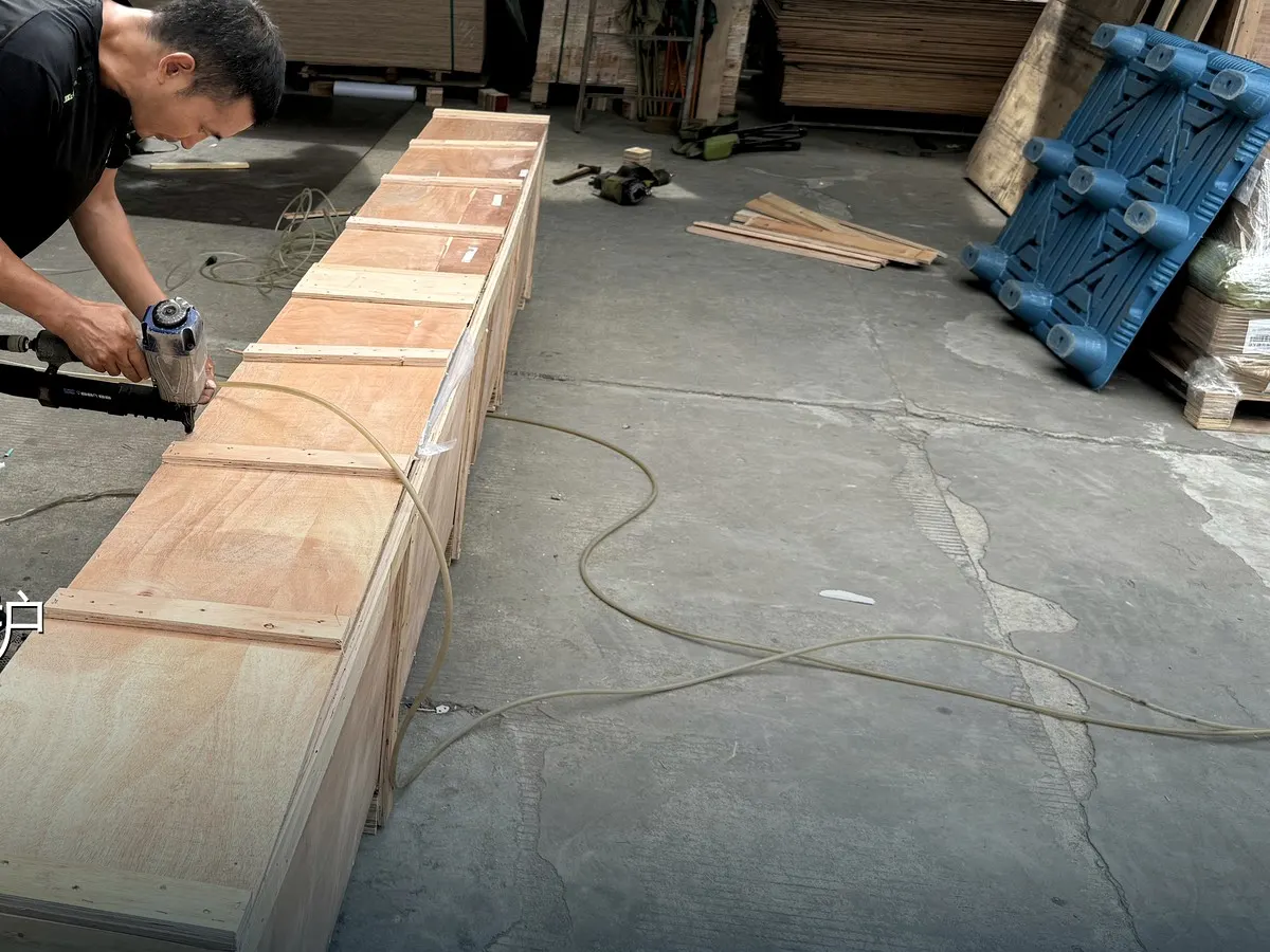 BuildCargo Logistics worker fastening a long custom crate for furniture cargo