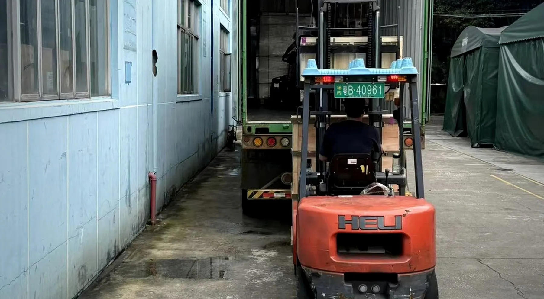 BuildCargo Logistics team loading a crated bulky shipment into a truck in Shenzhen